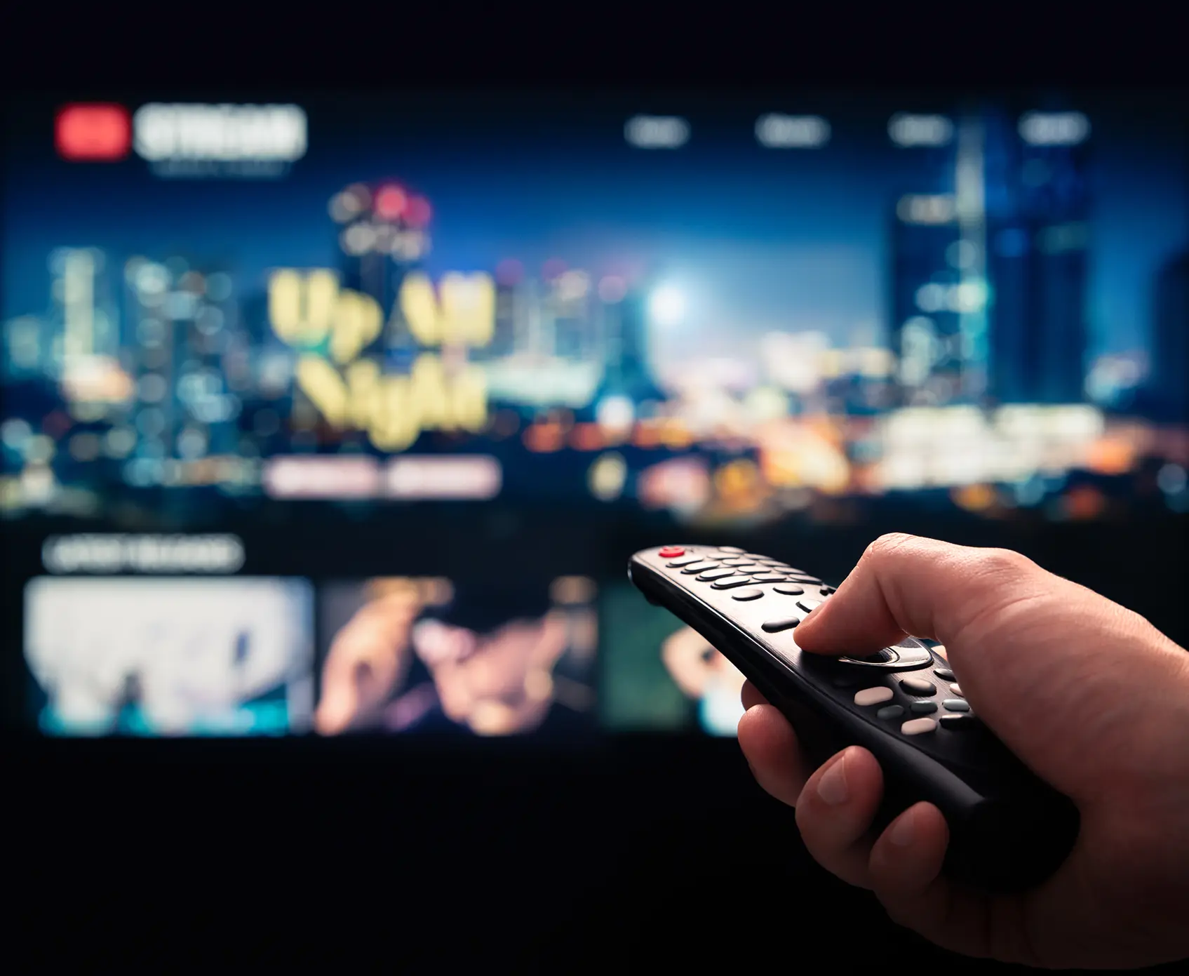 Hand holding remote, streaming service on TV.